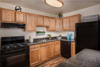 A kitchen with black appliances and wooden cabinets